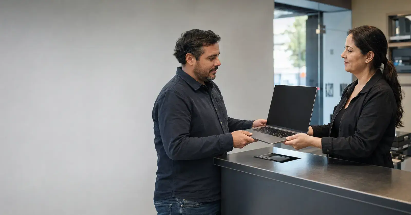Cliente recibiendo su notebook después de la revisión técnica